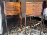 two wooden chairs sitting next to each other on a rug