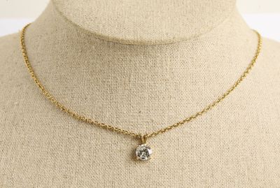 un collier en or orné d'un diamant sur un mannequin