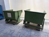 deux poubelles vertes posées l'une à côté de l'autre par terre