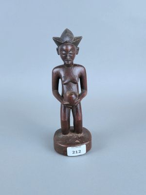 une petite statue en bois représentant un homme tenant un bébé dans ses bras