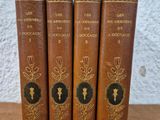 four old books sitting on top of a table next to each other