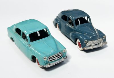 deux voitures jouets assises l'une à côté de l'autre sur une surface blanche