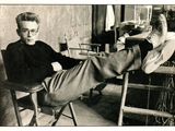 black and white photograph of a man sitting in a chair with his feet up