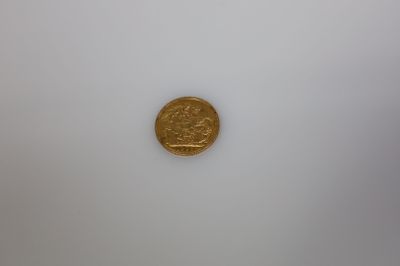 gros plan d'une pièce d'or sur une surface blanche