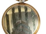 a gold pocket watch that is on display on a white background