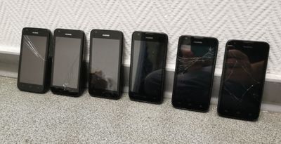 several cell phones are lined up in a row on the floor