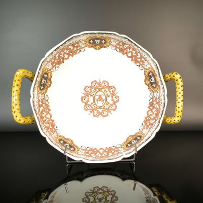 a plate with a yellow handle on a black table