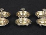 four silver plated candlesticks on a black background