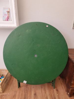 une table au plateau vert posée sur un parquet