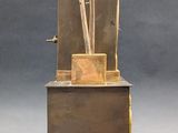 a bronze sculpture of a clock with arrows on it