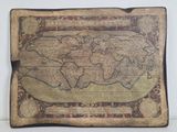 an old map of the world is displayed on a table