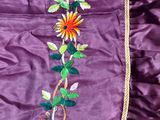 a close up of a purple dress with flowers and leaves on it