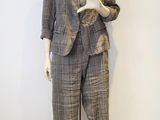 un mannequin vêtu d'un costume et d'un pantalon, posé sur un socle