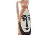 a vase with a face painted on the side of it