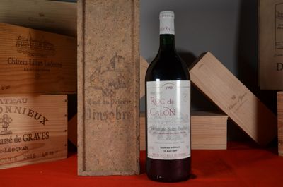 a bottle of wine sitting on a table next to wooden boxes