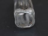 a glass bottle with a small amount of water inside of it