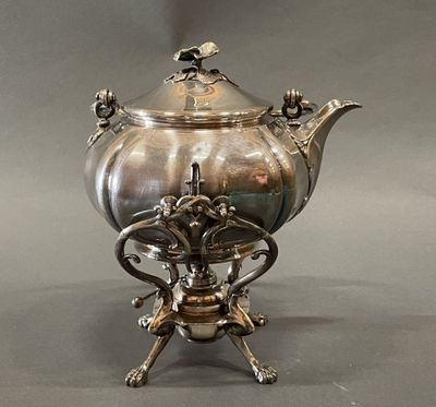 une théière en argent posée sur un socle, sur un fond gris
