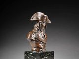 a bronze bust of a man with a hat on a marble base