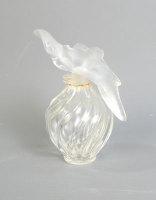 un vase en verre transparent surmonté d'un oiseau