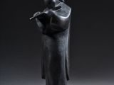statue of a man reading a book in a dark room