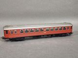 a red and silver train car on a gray surface