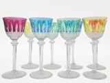 several different colored wine glasses are lined up in a row