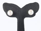 pearl studded earrings on a black leather hook on a white background
