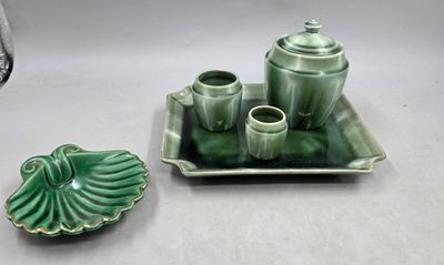un plateau vert sur lequel se trouvent un service à thé et une tasse