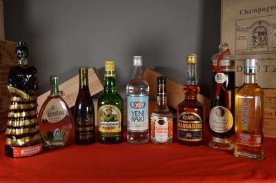 many bottles of alcohol on a table with a red table cloth