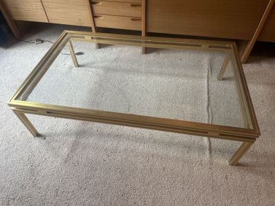 une table basse en verre surmontée d'un cadre doré