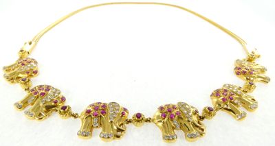 un gros plan sur un collier en or orné de pierres roses et blanches