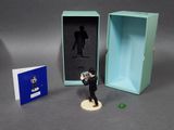 a small figurine of a man holding a camera in a box