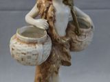 a figurine of a woman holding two pots