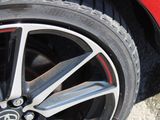 a close up of a red car tire on the road