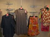 a lot of dresses hanging on a rack in a room