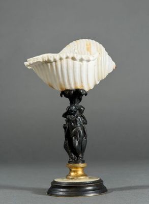 a black and white vase with a shell on top of it