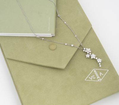 a green envelope with a silver necklace on it
