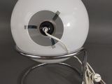 a white lamp that is sitting on a metal stand