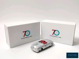 a silver toy car in front of a white box