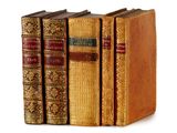 plusieurs vieux livres sont alignés sur une surface blanche