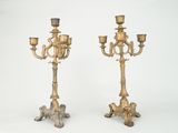 pair of antique brass candelabs on pedestals on white background
