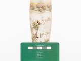 a white vase with a green card next to it