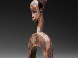 an image of a wooden sculpture of a woman with a hat on her head