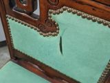 a chair with a green seat and a mirror behind it
