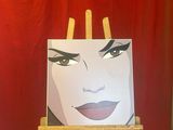 painting of a woman ' s face on an easel in front of a red curtain