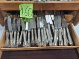 a lot of silverware on display in a wooden box