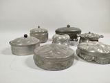 several silver metal containers with lids and lids on a white surface