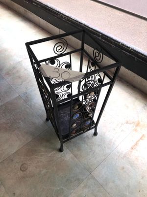 a black metal table with a glass top on a tiled floor
