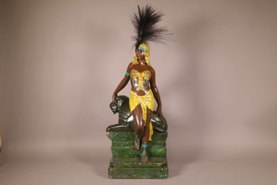 a figurine of a woman sitting on a green chair