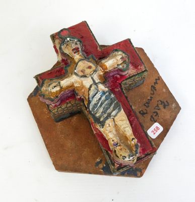 a small wooden cross with a painted image of jesus on it